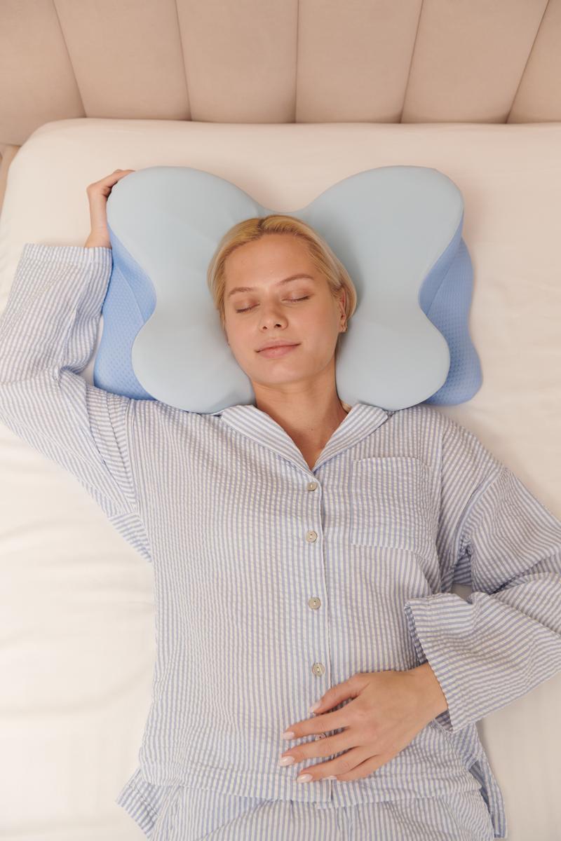 Woman sleeping peacefully on butterfly-shaped ergonomic pillow